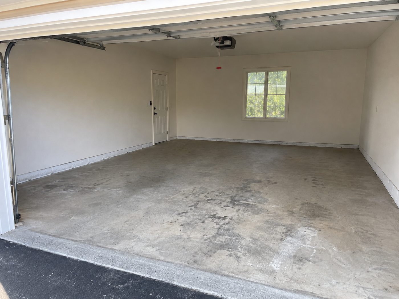 Stained bare concrete garage floor before epoxy