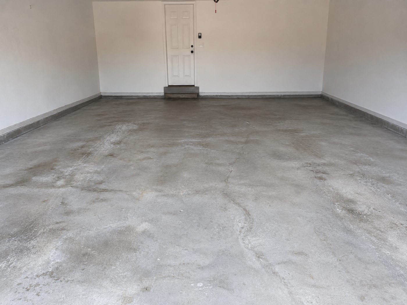 Worn cracked concrete garage floor before epoxy